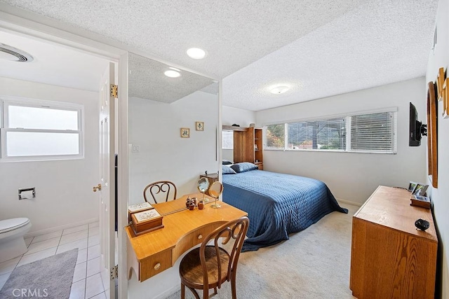 bedroom featuring light colored carpet and a textured ceiling