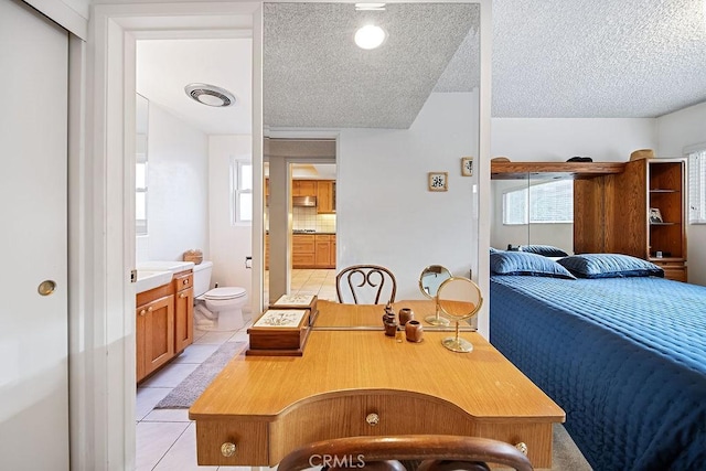 interior space with a textured ceiling and connected bathroom