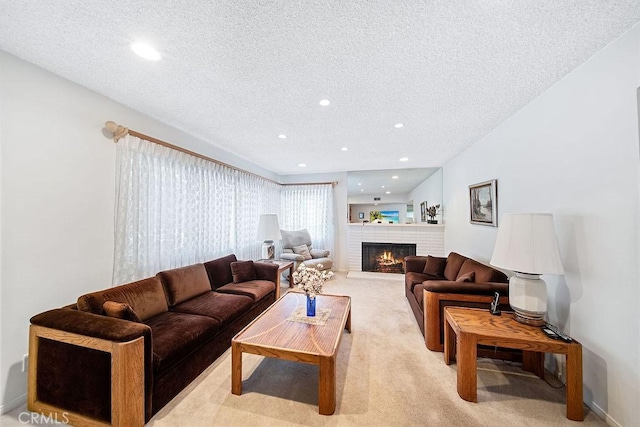 living room featuring a fireplace, a textured ceiling, and light colored carpet