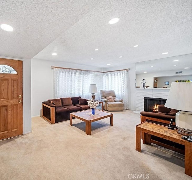 carpeted living room with a fireplace and a textured ceiling