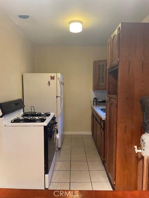 kitchen with white range with gas stovetop and light tile patterned flooring