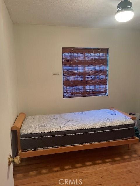 bedroom featuring wood-type flooring and a textured ceiling