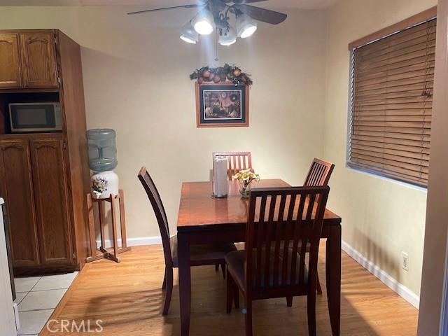 dining area with ceiling fan and light wood-type flooring