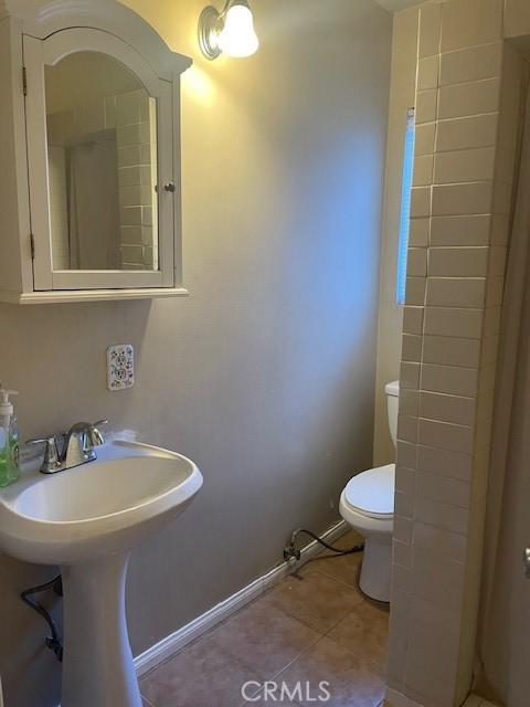 bathroom with sink, tile patterned flooring, and toilet