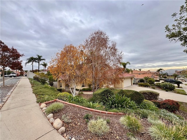 view of home's community featuring fence, a garage, and driveway