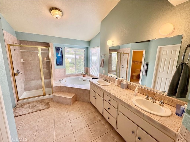 bathroom with a garden tub, a stall shower, lofted ceiling, and a sink