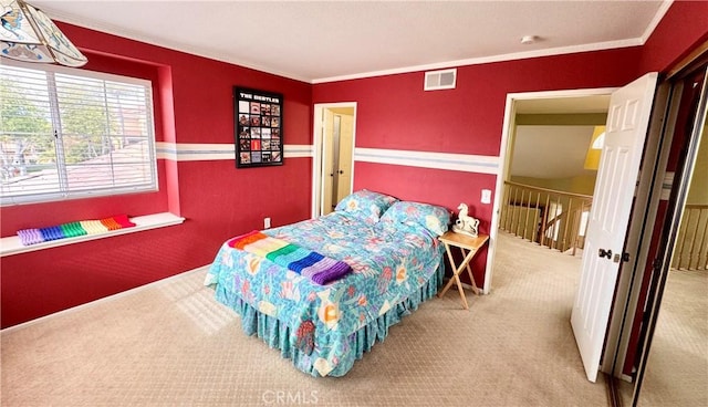 bedroom with visible vents, carpet floors, and ornamental molding