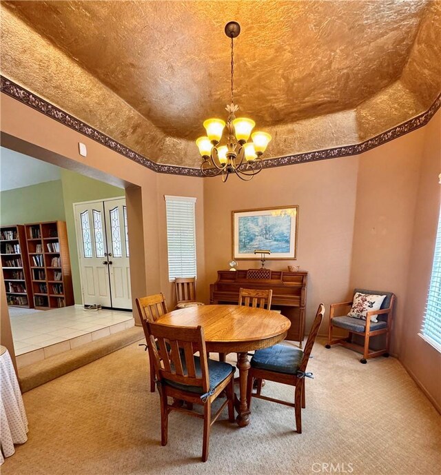 dining space featuring a tray ceiling, a notable chandelier, and carpet flooring