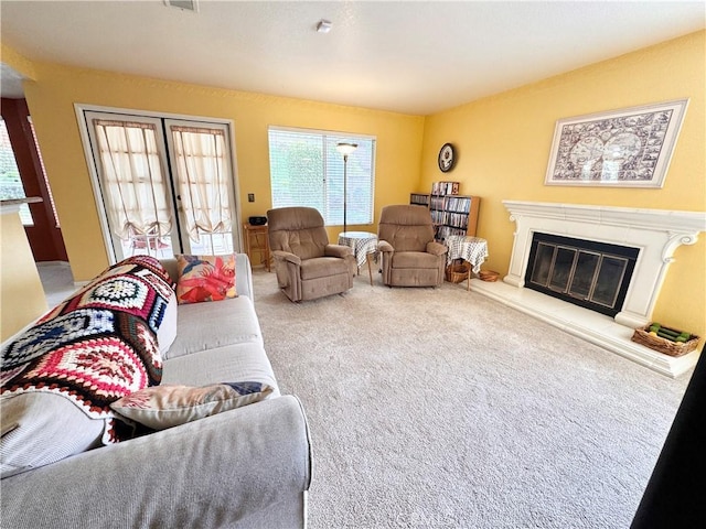 living area with visible vents, carpet, and a fireplace