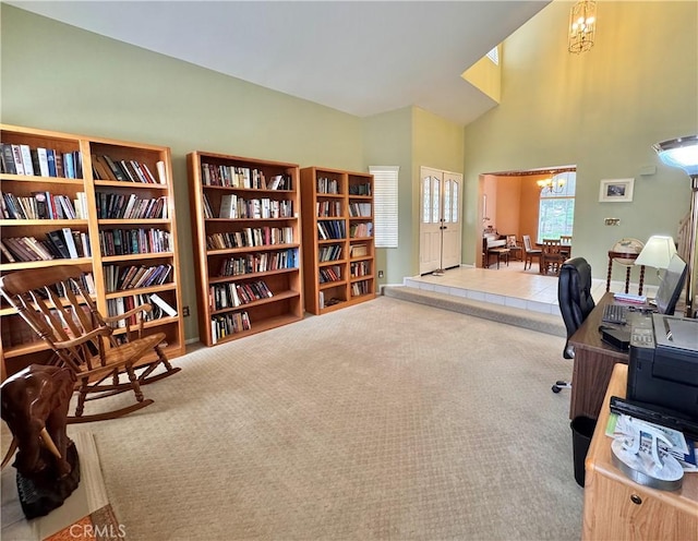 office featuring a towering ceiling, a chandelier, and carpet flooring