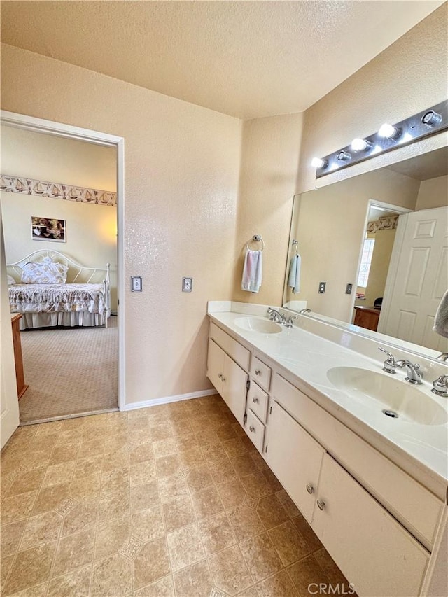 bathroom featuring double vanity, a textured ceiling, ensuite bath, and a sink