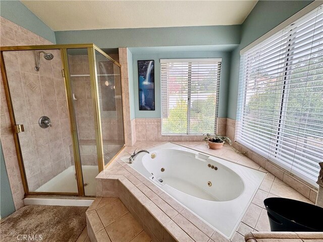 bathroom featuring tile patterned floors, a whirlpool tub, and a shower stall