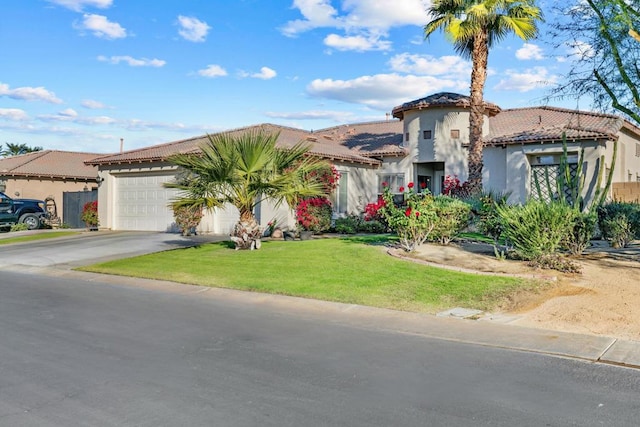 mediterranean / spanish house featuring a garage and a front yard