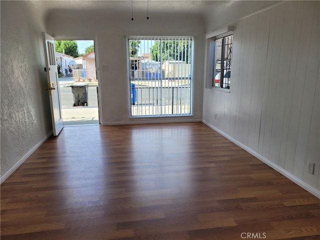 spare room featuring dark hardwood / wood-style flooring and a textured ceiling