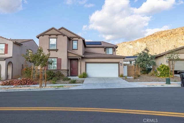 view of front of house featuring a mountain view, a garage, and solar panels