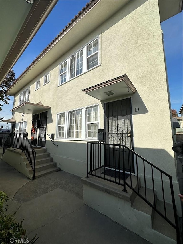 view of front of property with a tile roof and stucco siding