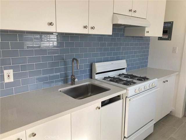 kitchen with light countertops, white appliances, a sink, and under cabinet range hood