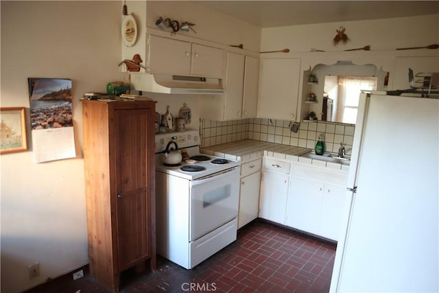 kitchen featuring white appliances, tile countertops, decorative backsplash, and white cabinets