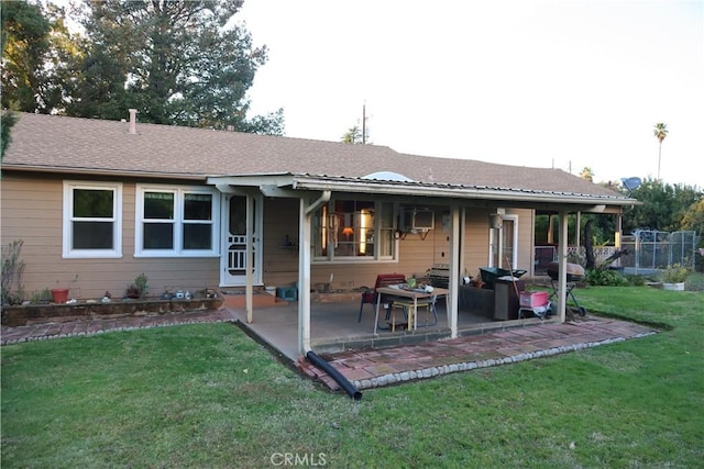 rear view of house with a lawn and a patio