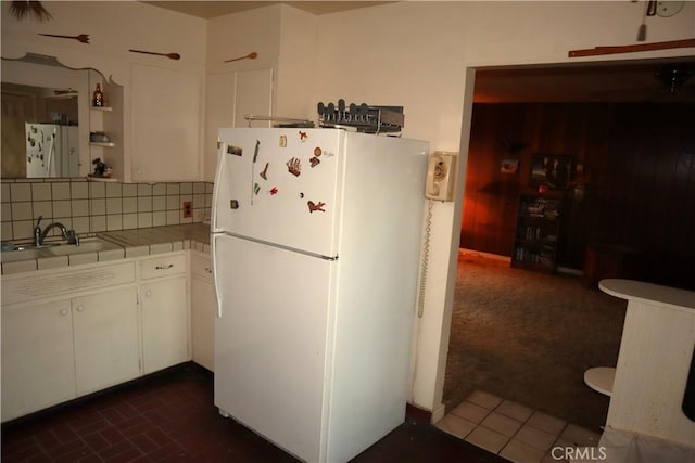 kitchen with sink, tile countertops, white fridge, decorative backsplash, and white cabinets