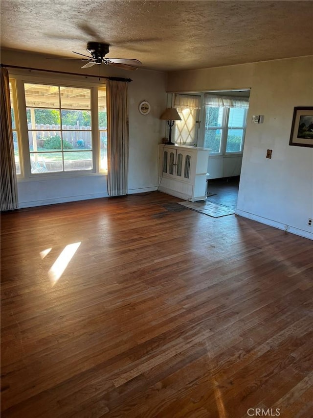 unfurnished room featuring a textured ceiling, dark hardwood / wood-style floors, and ceiling fan