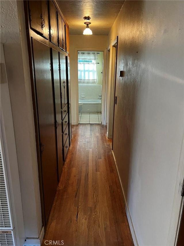 hallway featuring dark wood-type flooring and a textured ceiling