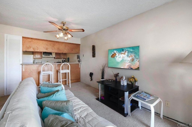 carpeted living room with ceiling fan and a textured ceiling