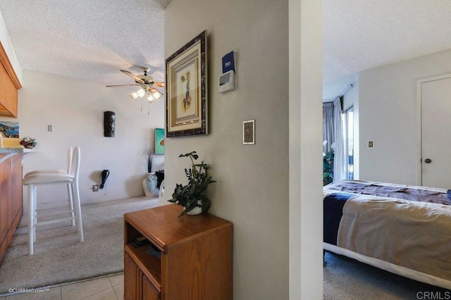 hallway with light tile patterned floors and a textured ceiling