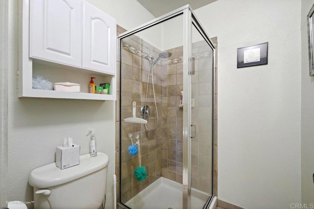 bathroom with toilet and a shower with door