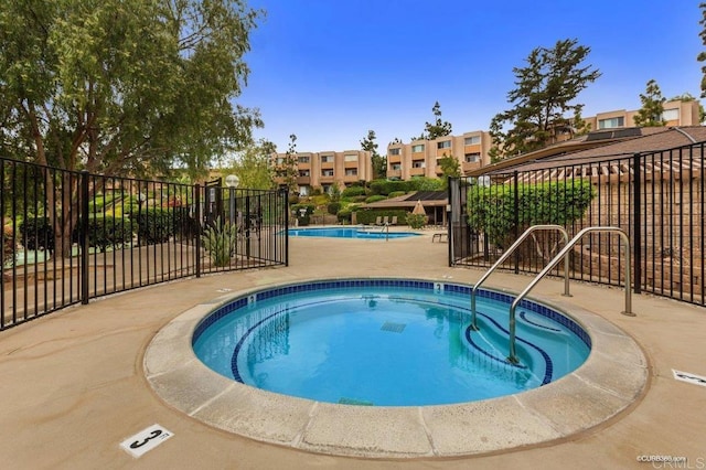 view of swimming pool with a patio area and a community hot tub