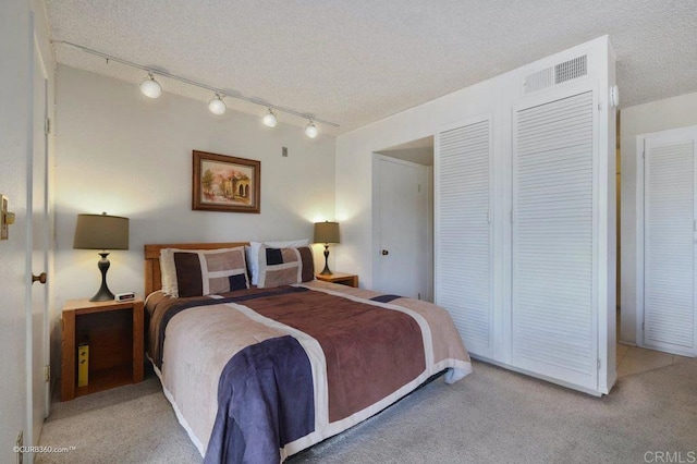 bedroom featuring light colored carpet and a textured ceiling