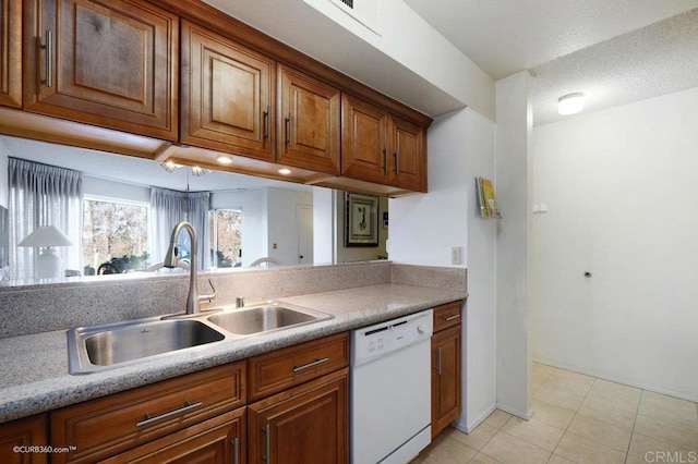 kitchen featuring dishwasher, light tile patterned floors, a textured ceiling, and sink