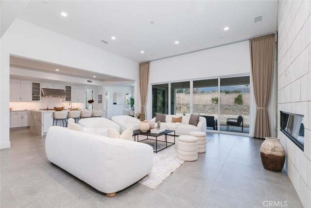 living room with sink and a tiled fireplace