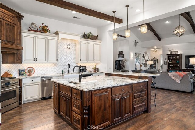 kitchen with dark brown cabinets, high end stove, decorative light fixtures, and tasteful backsplash