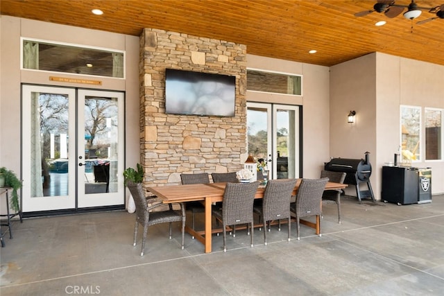 dining room with ceiling fan, concrete floors, wooden ceiling, and french doors