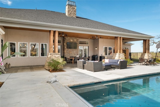 back of property with an outdoor hangout area, a fenced in pool, a patio, and ceiling fan