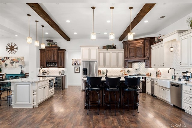 kitchen featuring a center island, stainless steel appliances, dark wood-type flooring, beamed ceiling, and pendant lighting