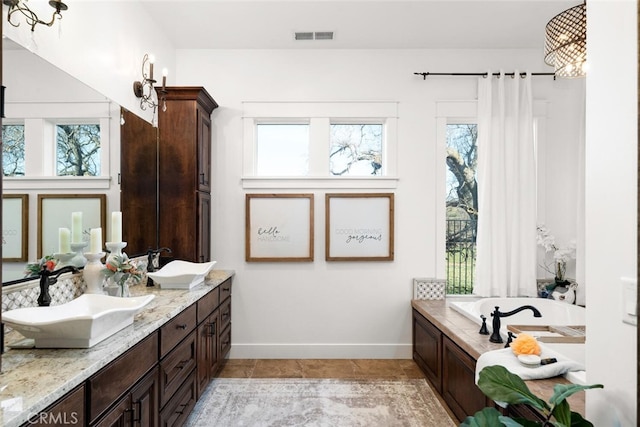 bathroom with a bath, vanity, and tile patterned floors