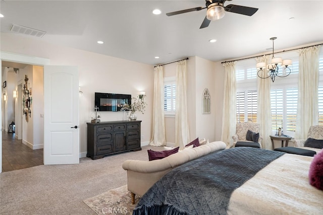 bedroom featuring ceiling fan with notable chandelier and light wood-type flooring