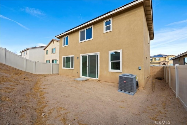 back of house with central AC unit