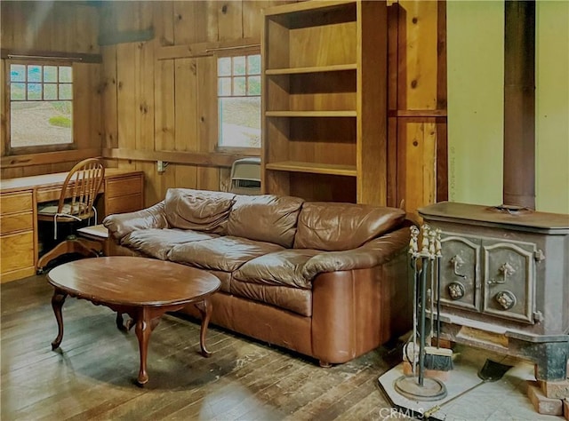 sitting room featuring wooden walls, built in desk, and hardwood / wood-style flooring