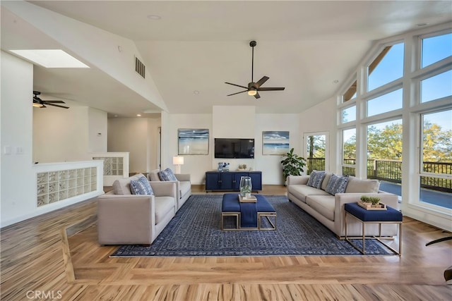 living room with plenty of natural light, wood-type flooring, and high vaulted ceiling