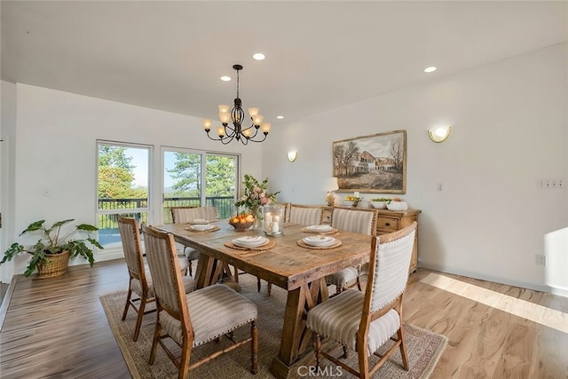 dining area featuring light wood-type flooring and a notable chandelier