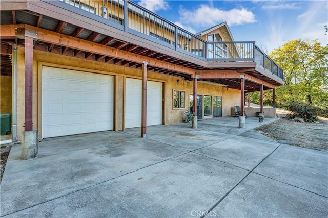 rear view of house featuring a balcony and a garage