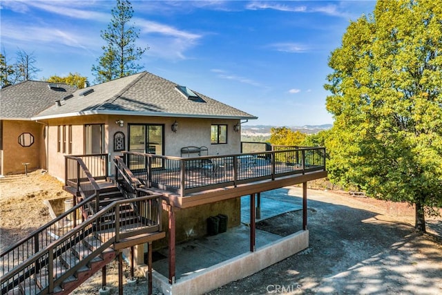 rear view of house featuring a patio and a deck