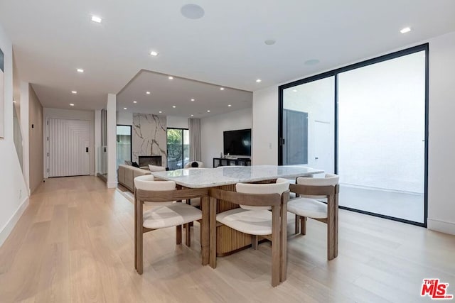 dining area featuring a fireplace and light hardwood / wood-style floors