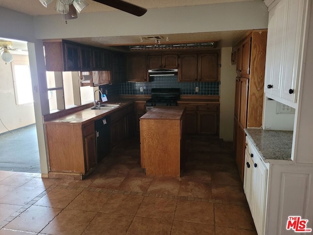 kitchen with black appliances, sink, decorative backsplash, a textured ceiling, and a kitchen island