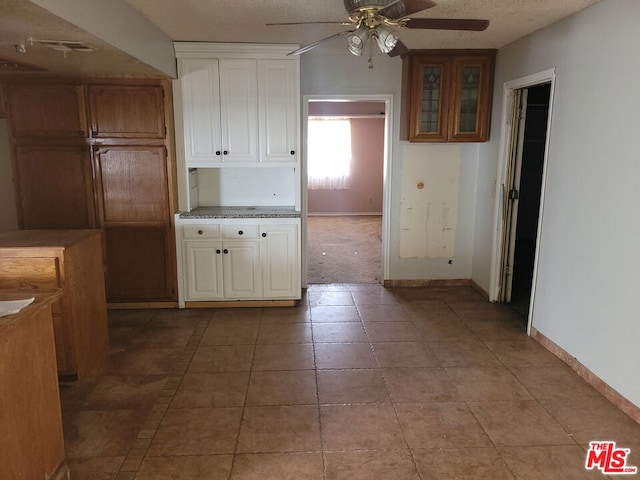 kitchen featuring ceiling fan, a textured ceiling, and light tile patterned floors