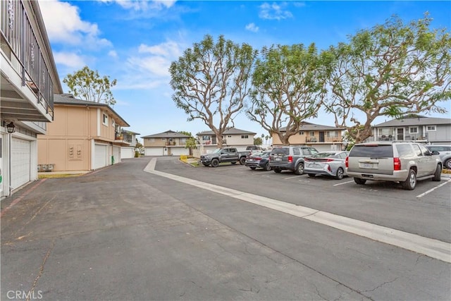 view of parking / parking lot featuring a garage