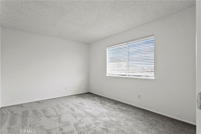 spare room with light colored carpet and a textured ceiling